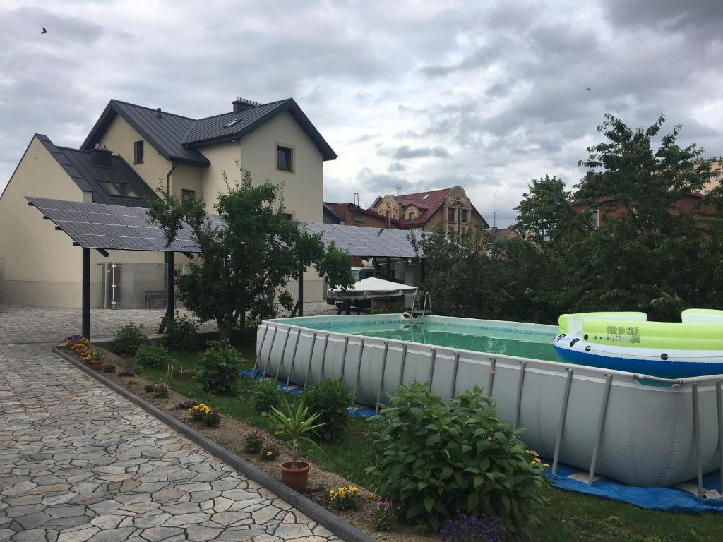 a swimming pool with a boat in a yard at Apartament Lębork (blisko Łeba) in Lębork