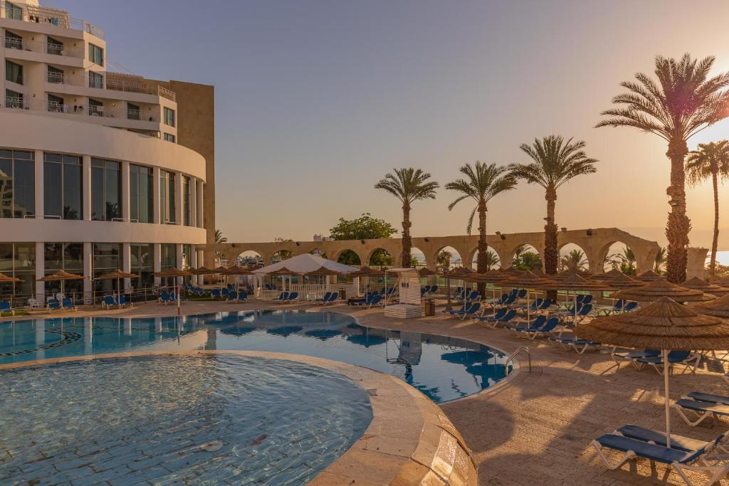 a large swimming pool with a large balcony at Daniel Dead Sea Hotel in Ein Bokek