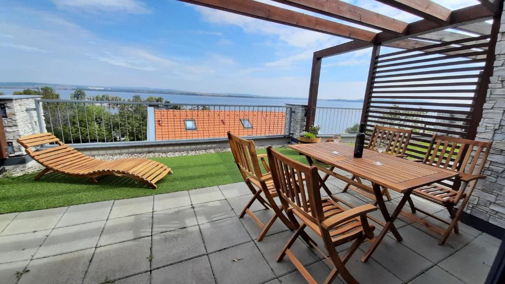 een patio met een houten tafel en stoelen op een balkon bij Apartmán Čtrnáct in Pavlov