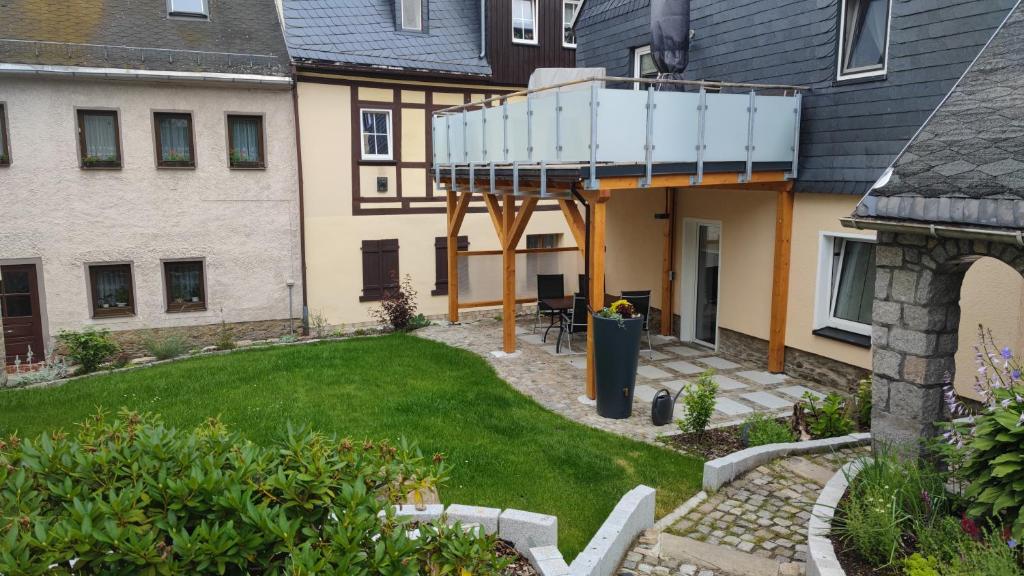 a house with a balcony on top of a yard at Ferienwohnung Dick Schwarzenberg in Schwarzenberg