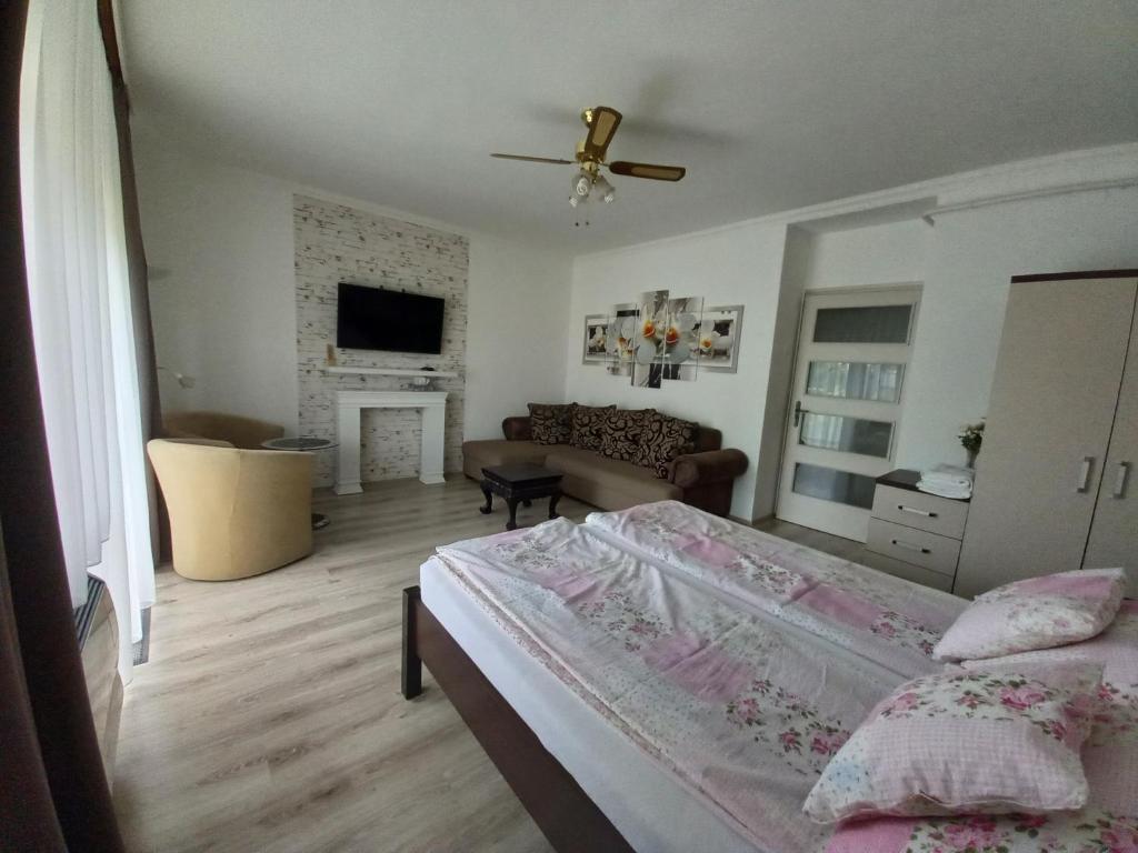 a bedroom with a bed and a living room at Kardos Apartman in Debrecen