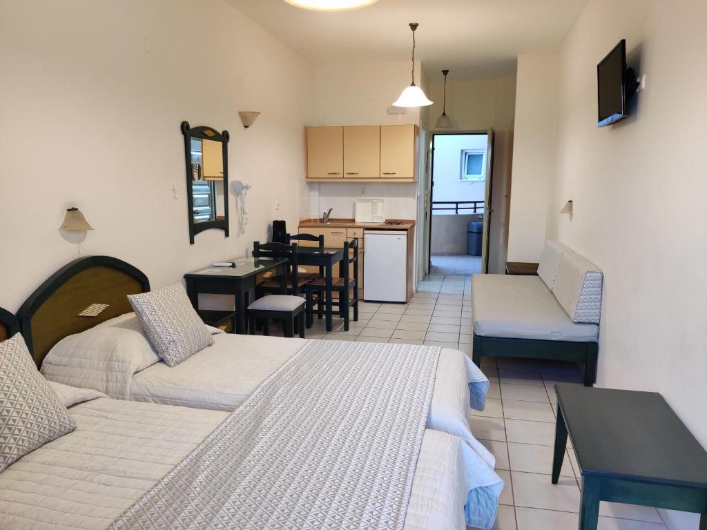 レティムノ・タウンにあるZannis Hotelのリビングルーム(ベッド2台付)、キッチンが備わります。