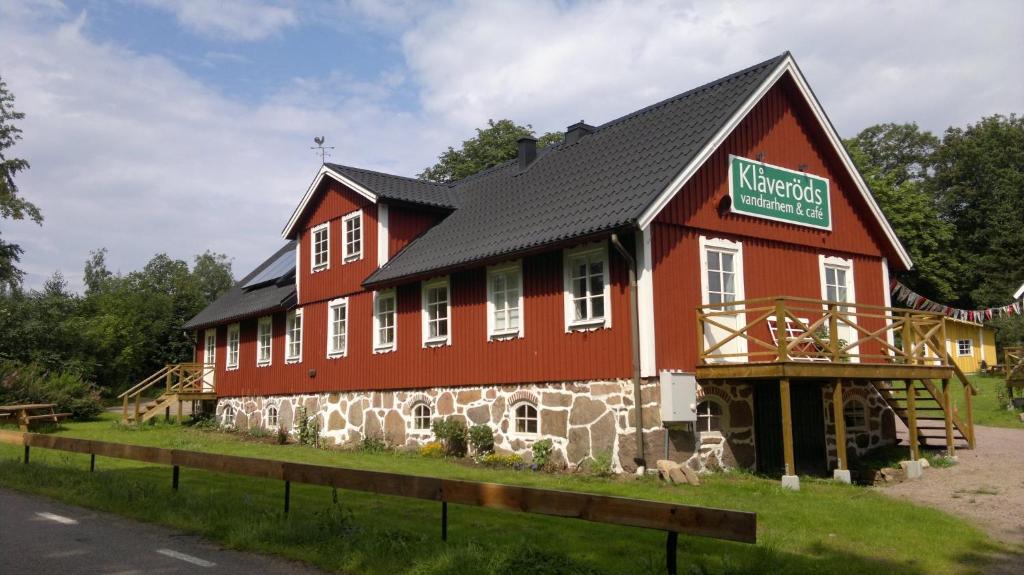 Kågeröd的住宿－Klåveröd logi & café，黑色屋顶的大型红色建筑