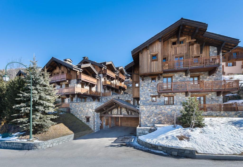 a large apartment building in the mountains with snow on the ground at Chalet Rose in Saint-Martin-de-Belleville