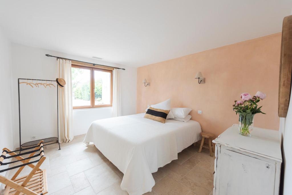a bedroom with a white bed and a vase of flowers at La Petite Ruche, 1 bedroom Gite in the Luberon in Apt