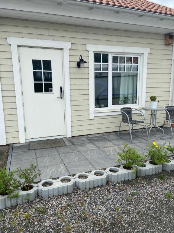 a patio with a white door and a table and chairs at Katthagen in Skara