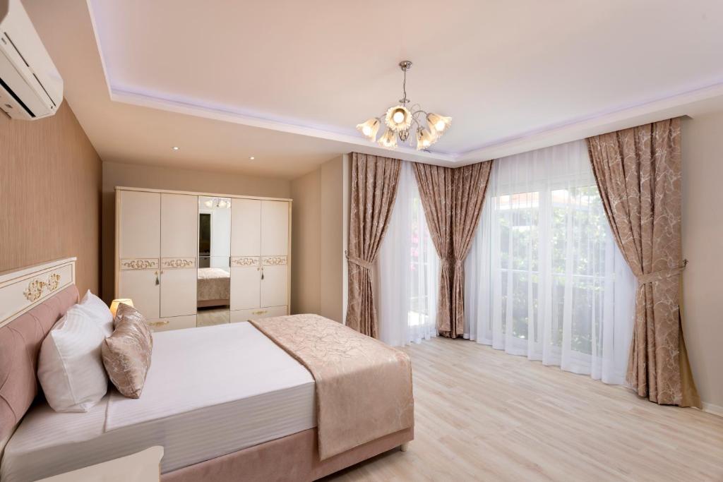 een slaapkamer met een groot bed en een kroonluchter bij Onix Apart Hotel in Antalya