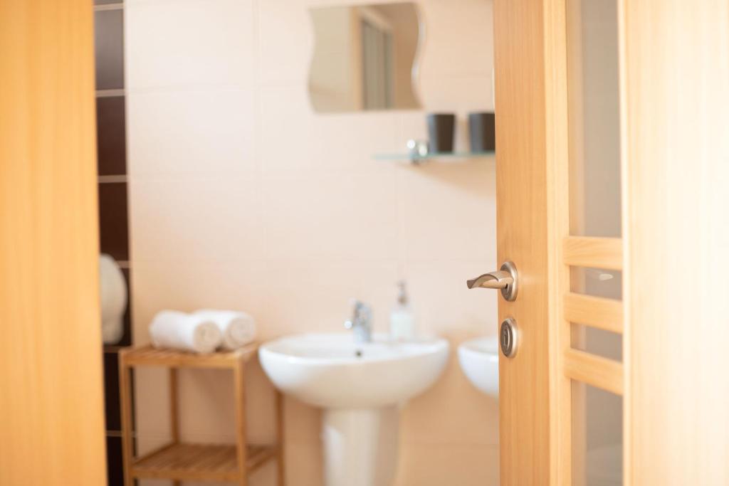 bagno bianco con lavandino e specchio di Guest house Fleurs a Liptovský Mikuláš