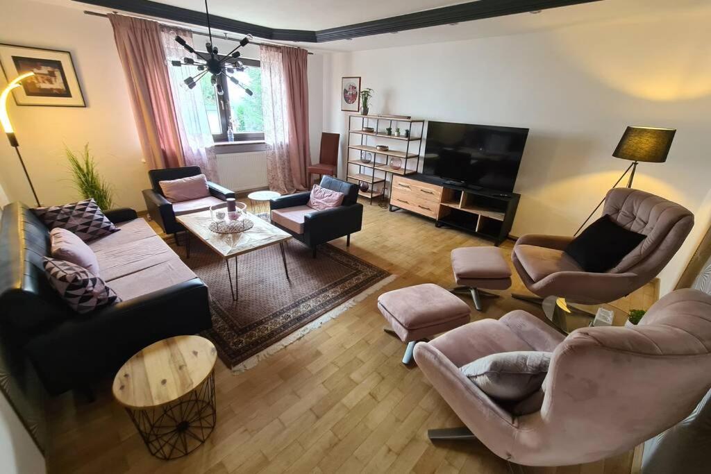 Il comprend un salon doté de meubles et d'une télévision à écran plat. dans l'établissement Charmantes Wohnen in Lichtenfels, à Lichtenfels
