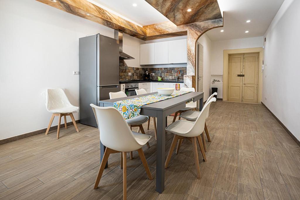 a kitchen with a table and chairs in a room at Mola’s Square House in Mola di Bari