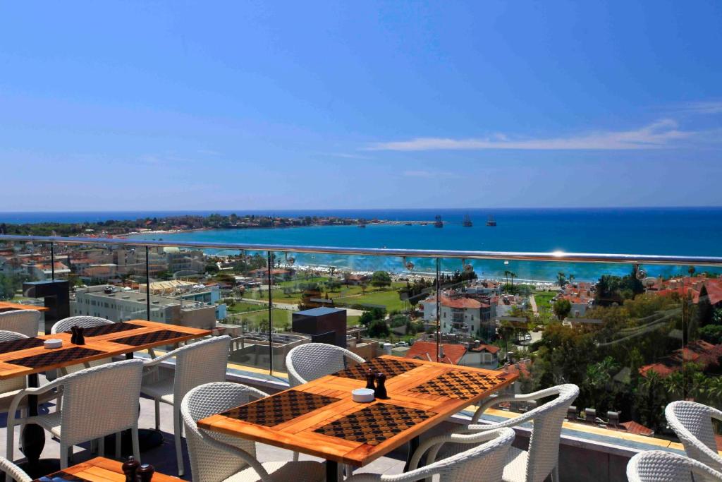 una mesa y sillas en un balcón con vistas al océano en Side Su Hotel - Adult Only (+16), en Side