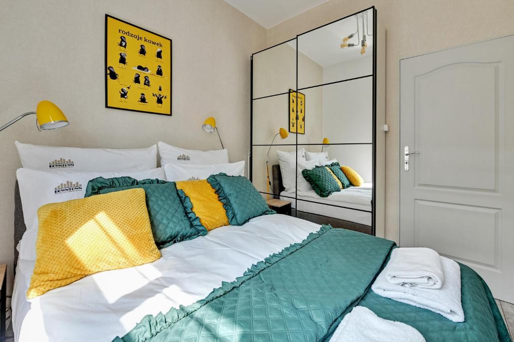 a bedroom with a large bed and a mirror at Downtown Apartments Old Town Ogarna in Gdańsk