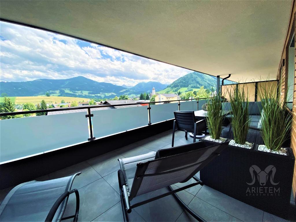 a balcony with a view of the water and mountains at Arietem-Apartment in Gröbming