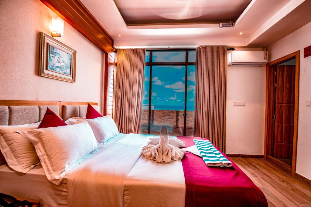 a bedroom with a large bed with a large window at Araamview in Hulhumale