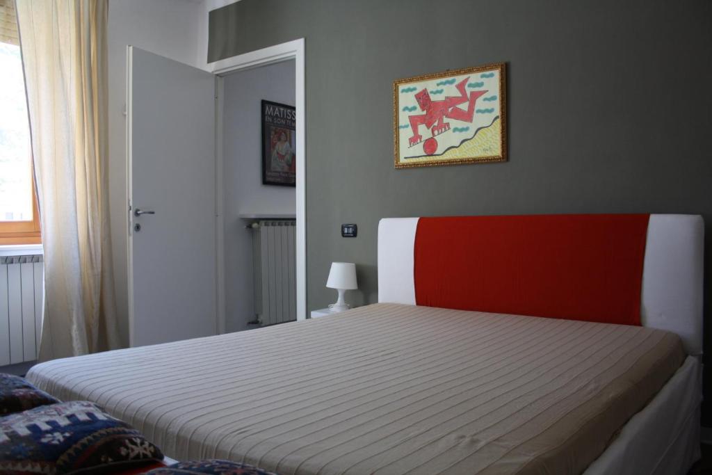 una camera con letto con testiera rossa e bianca di Melograni 28 a Omegna