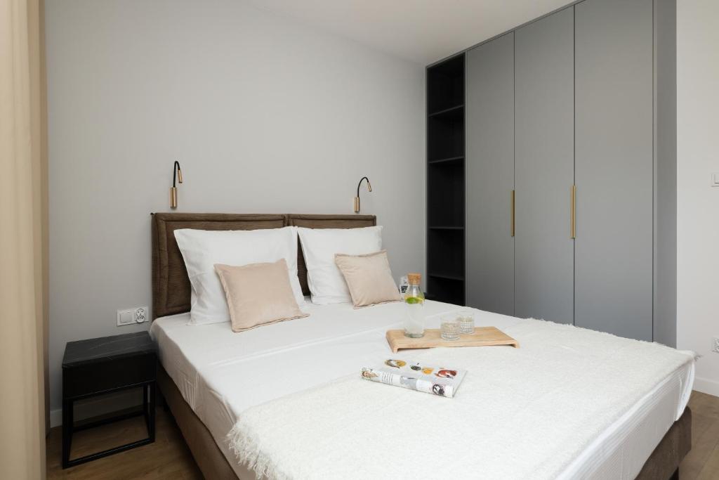 a bedroom with a large white bed with a wooden headboard at Apartamenty Gryf Rewal in Rewal