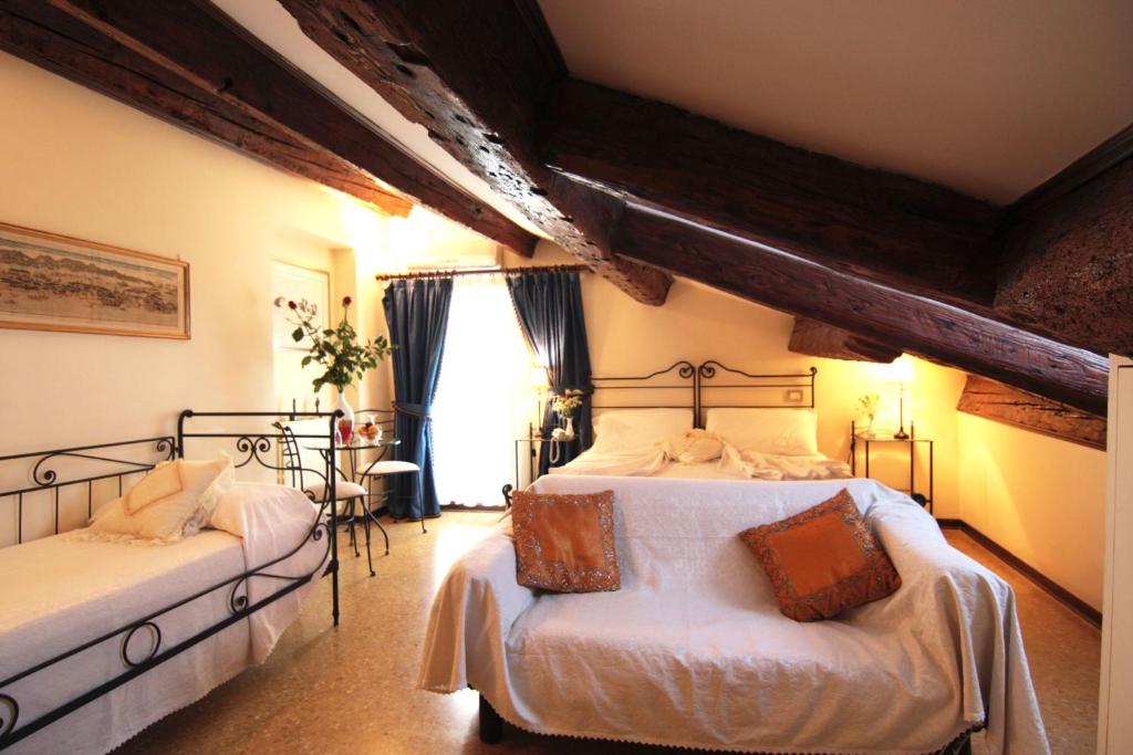 a bedroom with two beds and a window at Ca' Riccio in Venice