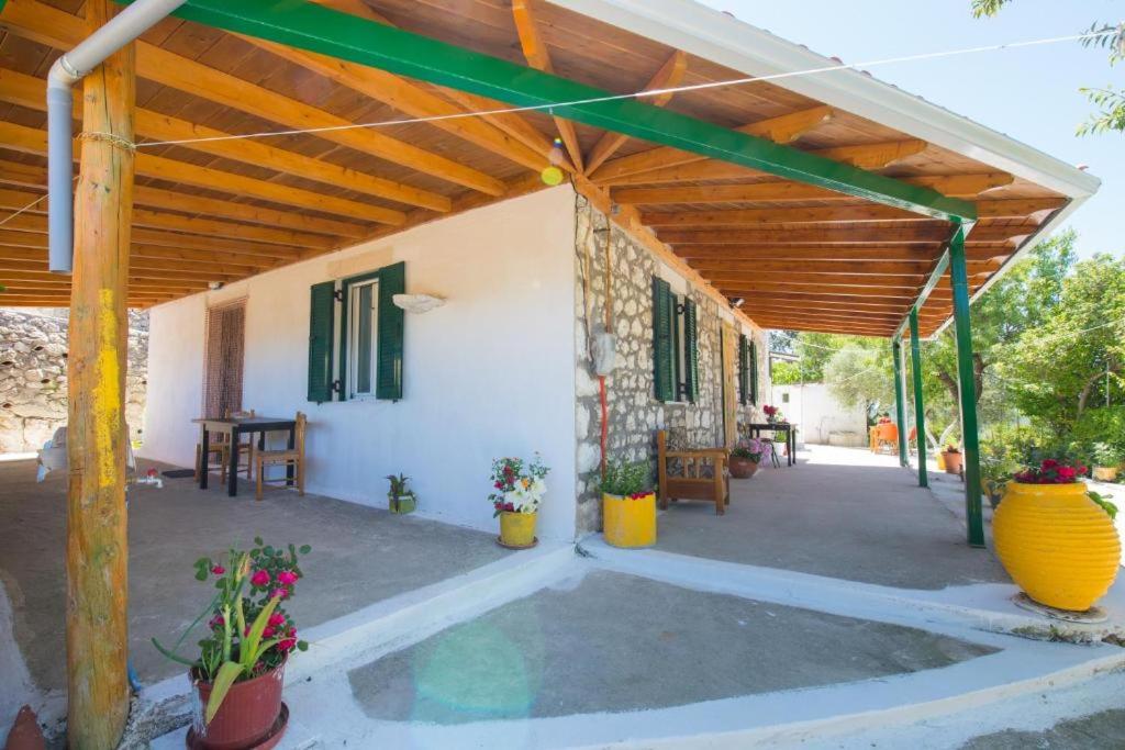 a porch of a house with a wooden roof at Πέτρινο σπίτι in Lazaráta