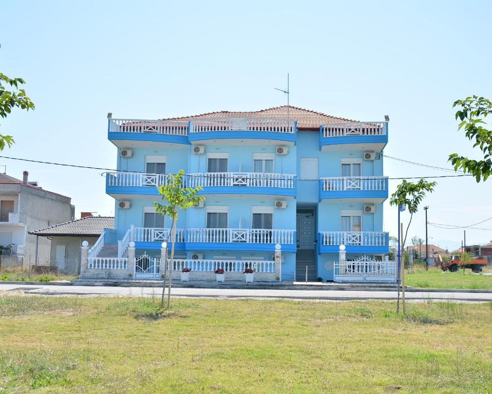 a blue house with a white balcony at Hotel Paris in Paralia Katerinis