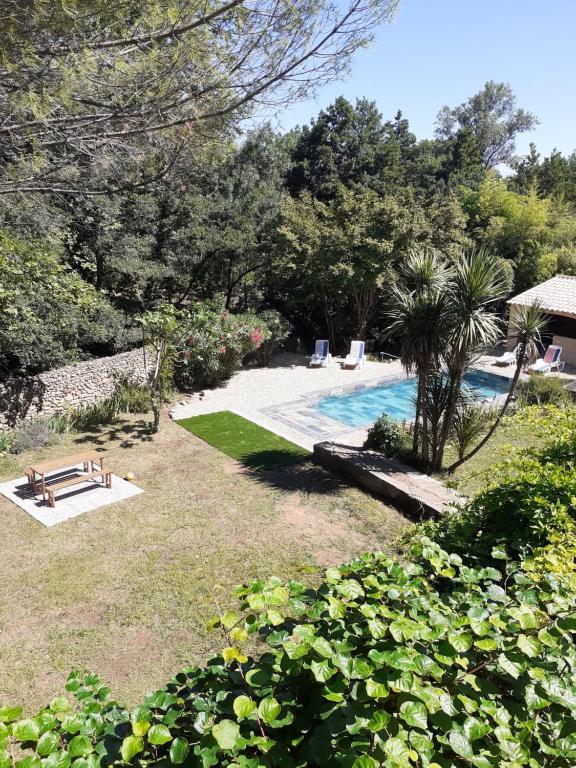 une cour avec une piscine, une table de pique-nique et un banc dans l'établissement Au Moulin du Martinet, à Saint-Chinian