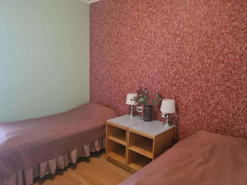 a room with two beds and two tables with lamps at Uhtjärve Ürgoru Nõiariik in Antsla