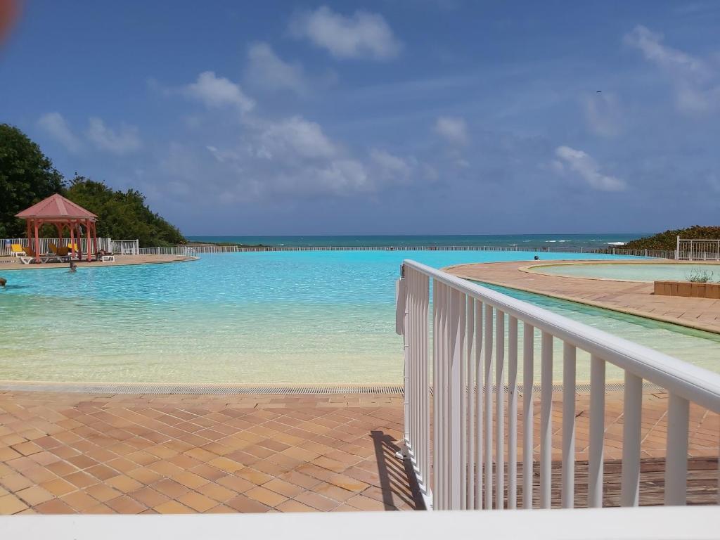 a view of a swimming pool with blue water at ANSE DES ROCHERS St François CORAIL 306 in Saint-François