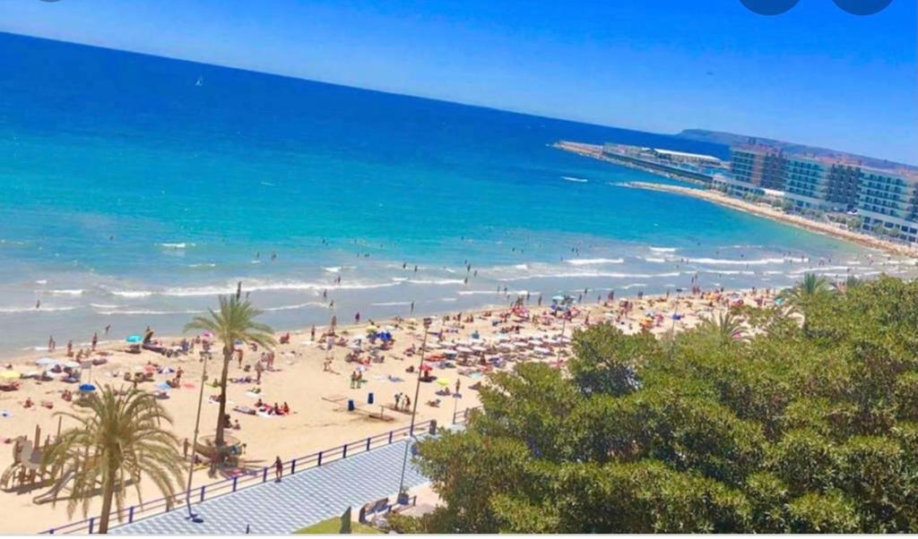 a beach with a lot of people and the ocean at Estudiotel Heart of Alicante with sea view in Alicante