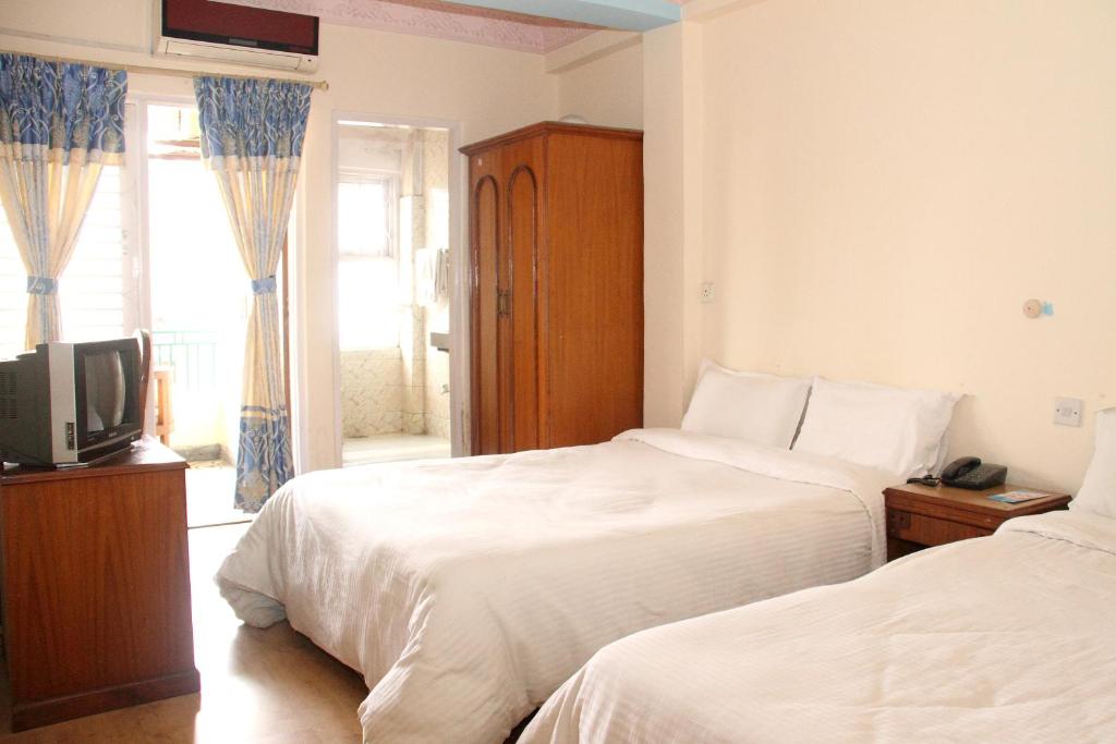 a hotel room with two beds and a television at Trekkers Home in Kathmandu