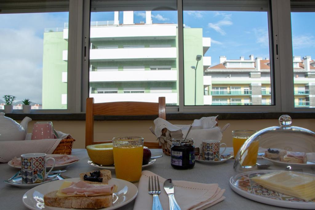 uma mesa coberta com pratos de comida e sumo de laranja em Vizinha’s Dad’s Apartment em Ponta Delgada