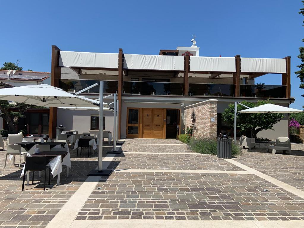 a building with a patio with tables and umbrellas at Tenuta Micoli in Frisa