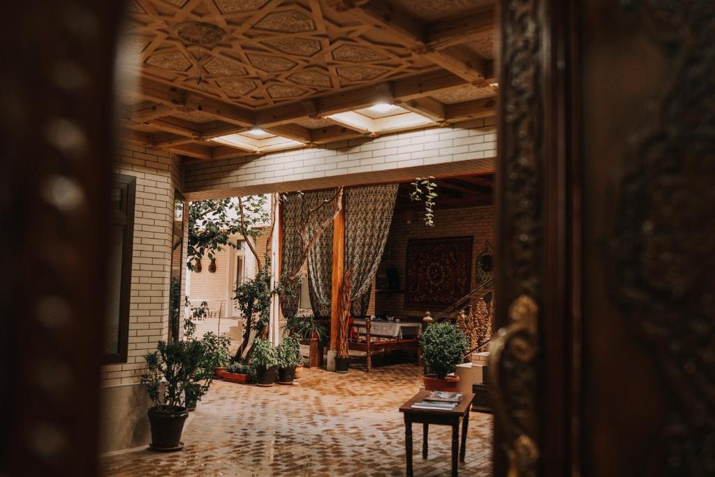 um corredor com vasos de plantas num edifício em Hotel Dilshoda em Samarkand
