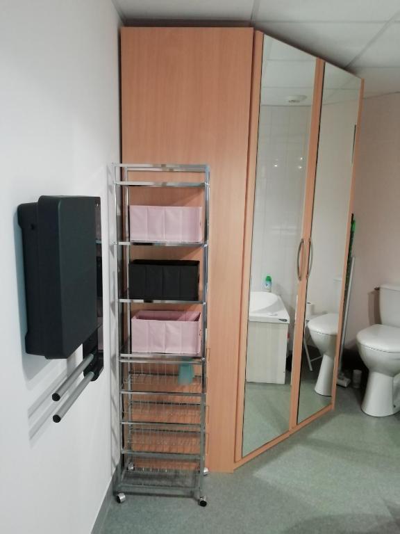 a bathroom with a toilet and a tv and a mirror at château de Locquéran Pierres et filets bleus in Plouhinec