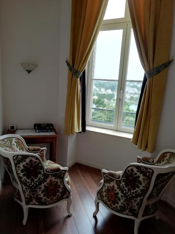 two chairs in a room with a large window at château de Locquéran Pierres et filets bleus in Plouhinec