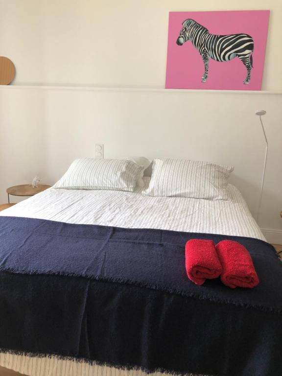 a bedroom with a bed with two red pillows on it at Chambre indépendante au Manoir de la Célinais côté jardin in Saint-Aubin-du-Cormier