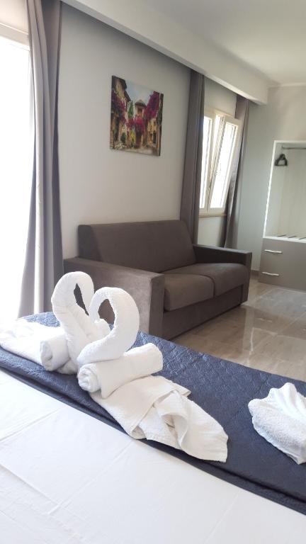 1 dormitorio con 1 cama con toallas en Blue Marine - Free Parking, en Tropea