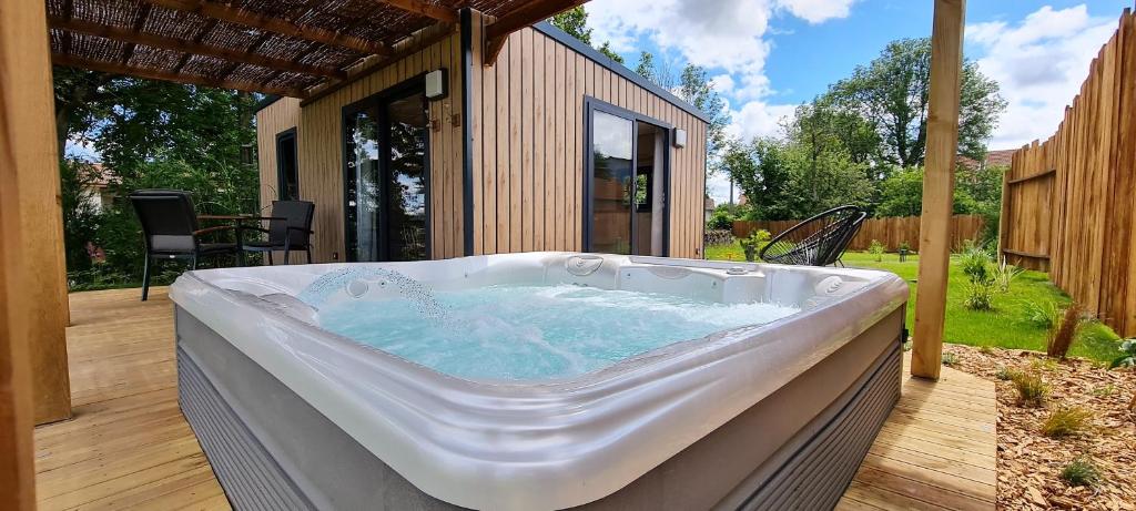 bañera de hidromasaje en una terraza de madera en Domaine des graminées, en Jeanménil