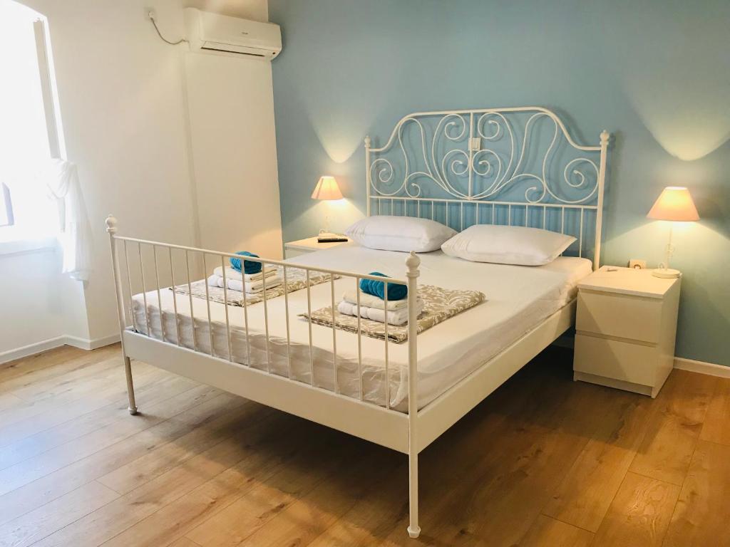 a white bed with a blue headboard in a bedroom at Seaside Old House Apartment in Supetarska Draga