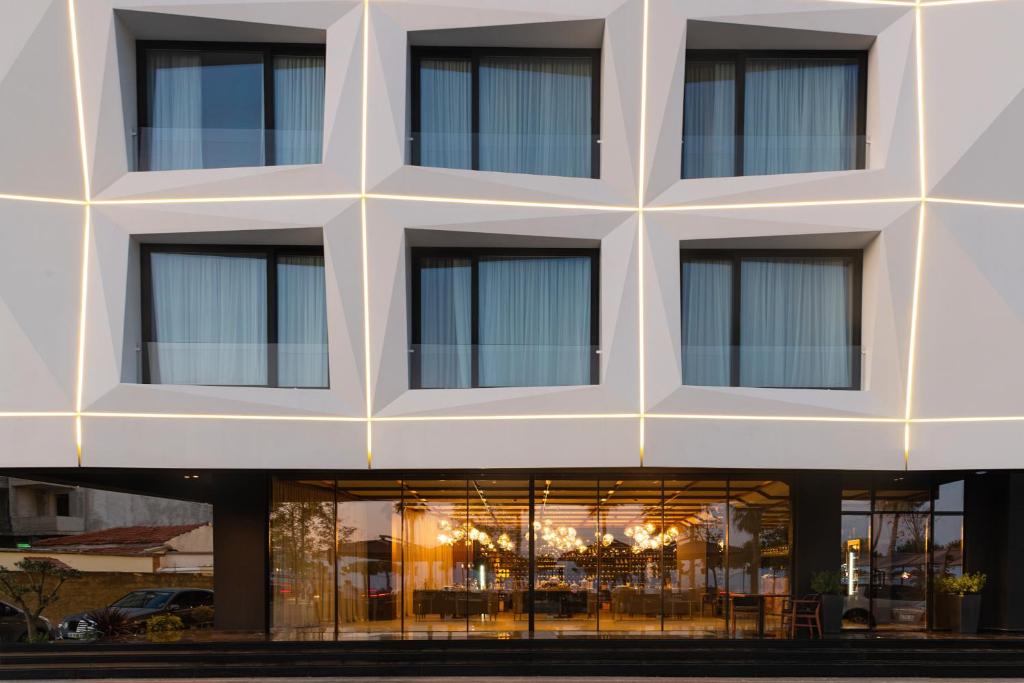 a large white building with windows at Chic Boutique Hotel Vlore in Vlorë