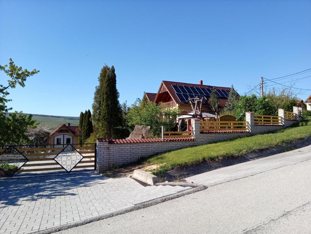 una casa con una valla a un lado de la carretera en Eszter-lak, en Monostorapáti