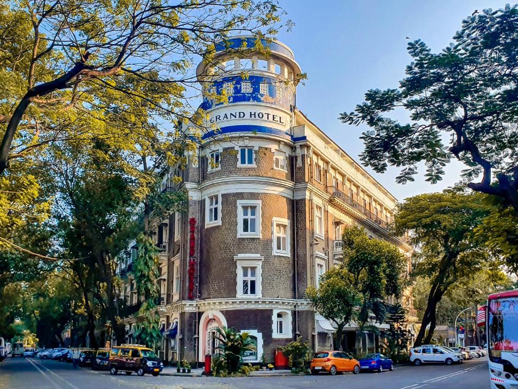 ein Gebäude mit einem Uhrturm darüber in der Unterkunft Grand Hotel Mumbai - Ballard Estate, Fort in Mumbai