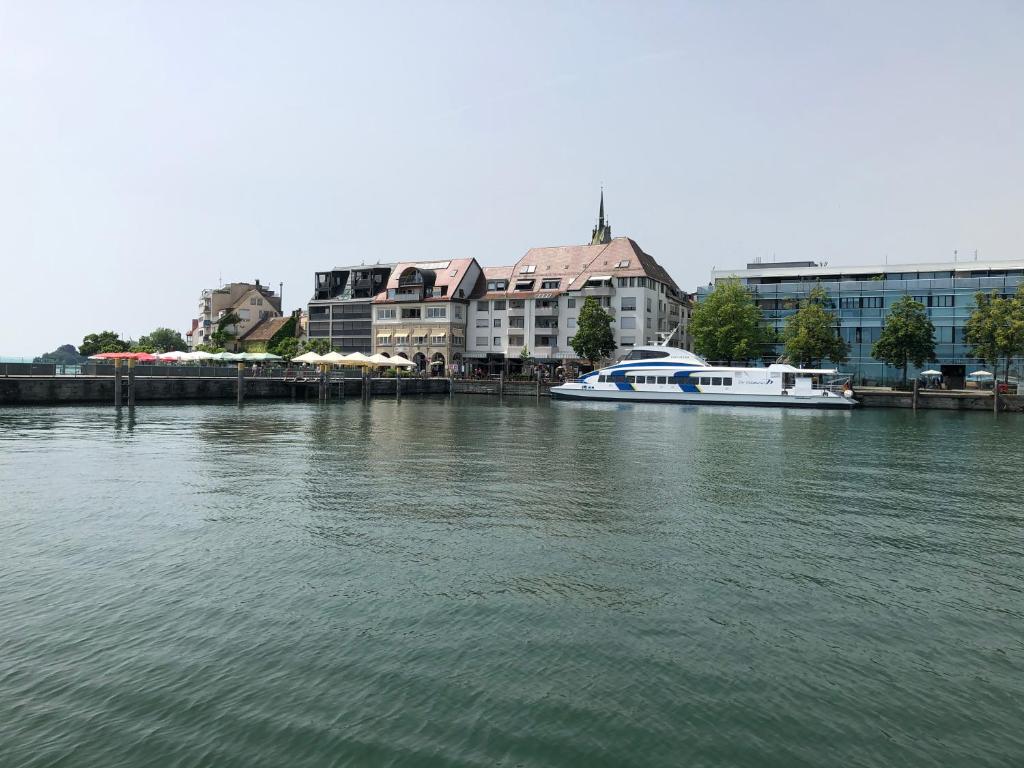 a boat is docked in a river with buildings at Özkurt-2 in Friedrichshafen