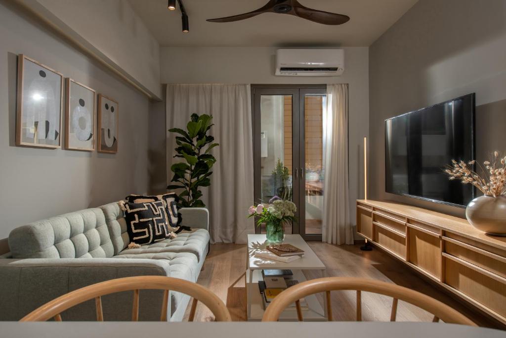 a living room with a couch and a flat screen tv at The Blossom-Premium living residence at Heraklion in Heraklio Town