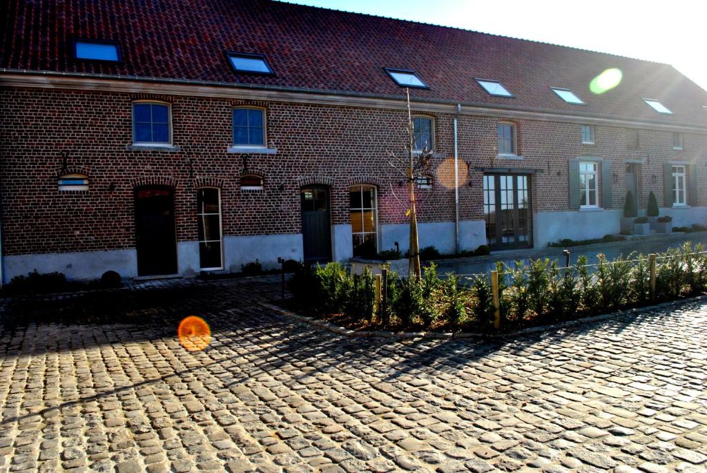 un bâtiment en briques avec une rue pavée en briques dans l'établissement B&B Louis1924, à Dilbeek