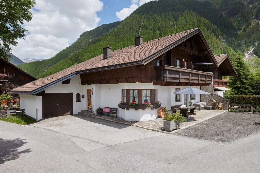 una casa en las montañas con una mesa en Apart Bergzeit, en Umhausen