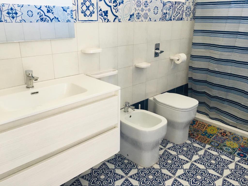 e bagno con servizi igienici, vasca e lavandino. di Villa Zaffiro a Lampedusa