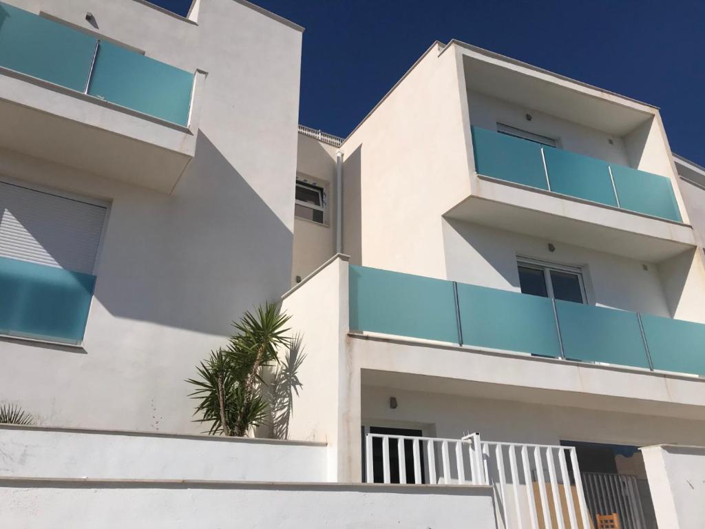 a white building with blue balconies on it at Living one Bed and Breakfast in Peniscola