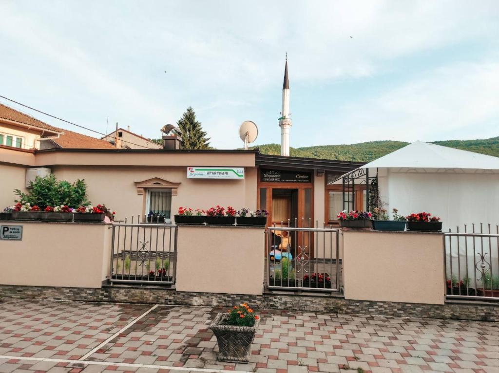 a building with potted plants and a mosque at Apartment Beganovic-Centar in Kulen Vakuf