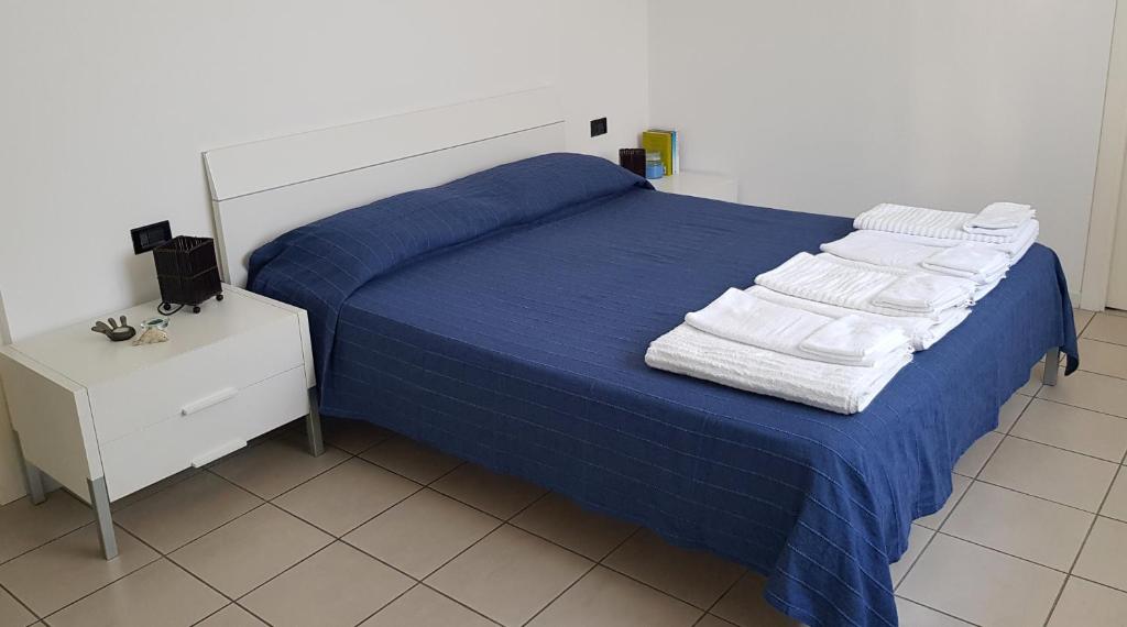 sypialnia z niebieskim łóżkiem i ręcznikami w obiekcie Casa Nicky w mieście Abano Terme