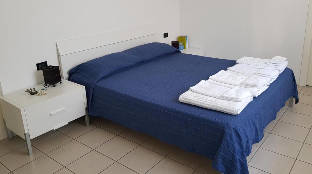 sypialnia z niebieskim łóżkiem i ręcznikami na nim w obiekcie Casa Nicky w mieście Abano Terme