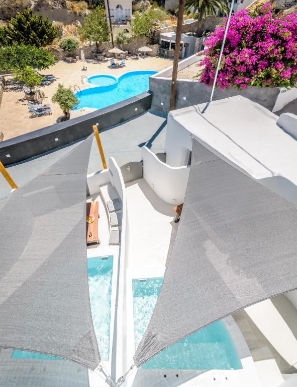 a view of a swimming pool with an umbrella at Anila Suites in Fira